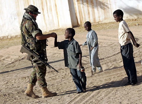 Dessie Butler, Kilkenny, a EUFOR Irish trooper, shaking hands with a young boy, on static patrol during a quick responce force patrol in Goz Beida, Chad, Africa.