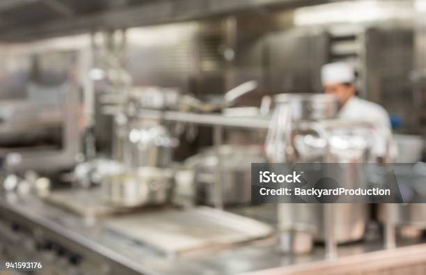 Defocused Chef Preparing Food In Commercial Kitchen Stock Photo - Download Image Now