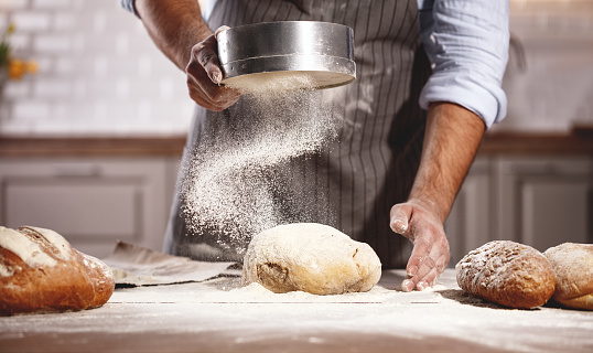 hands of the baker's male knead dough