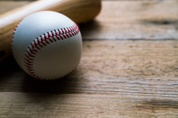 istock baseball and baseball bat on wooden table background, close up 941621100