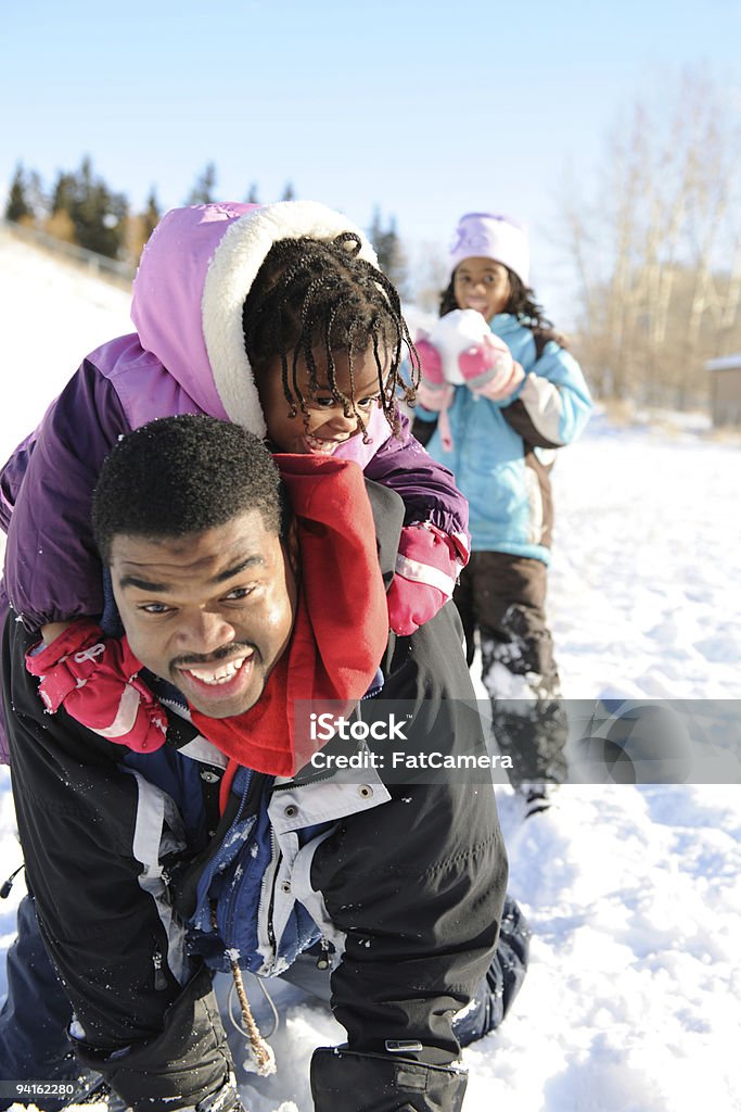 Snowtime Fun Girls having fun in the snow with their father.  -   Family Stock Photo