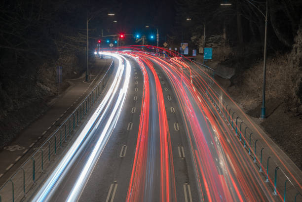 istock Traffic at night, long exposure light trails on highway through park 941630392