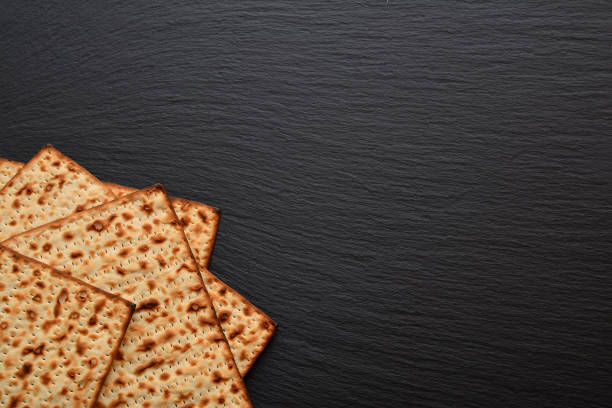 fette di matzo su piatto, tavola, vassoio di ardesia nera. pane pasquale fresco a base di farina di grano sotto forma di torte secche molto sottili. - seder plate seder plate judaism foto e immagini stock