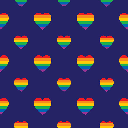 Vector seamless pattern of rainbow striped hearts on a dark blue background.