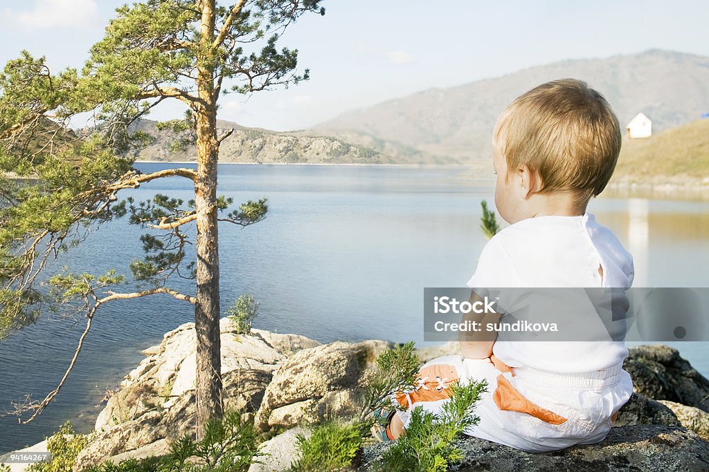 Buchtarma. Criança sentada na praia de entrada. - Foto de stock de 12-23 meses royalty-free