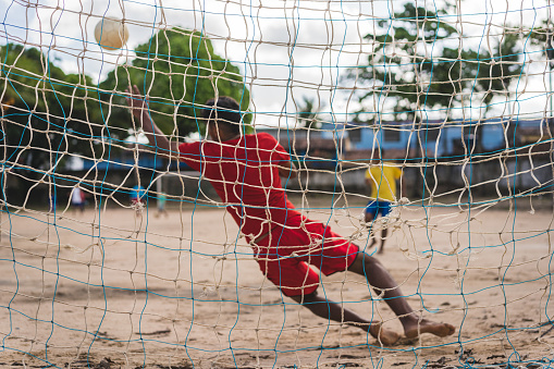 Soccer player at the penalty in the sand field in northeastern of Pernambuco, Brazil.