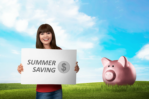 Young asian woman holding board with text Summer saving. Summer saving concept