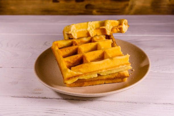 istock Ceramic plate with belgian waffles on wooden table 941656470