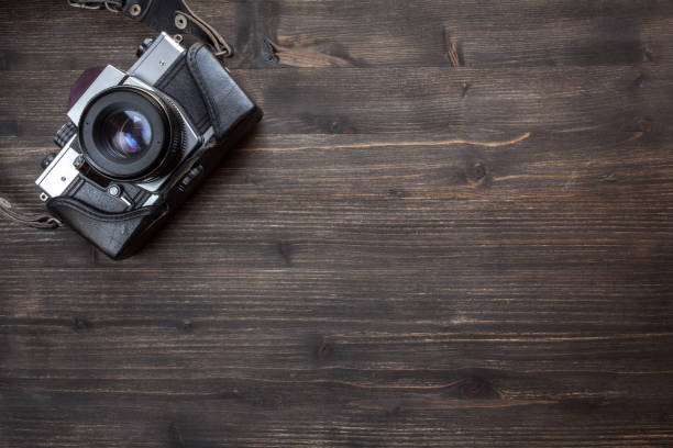 istock Old retro camera on wooden table background 941664400