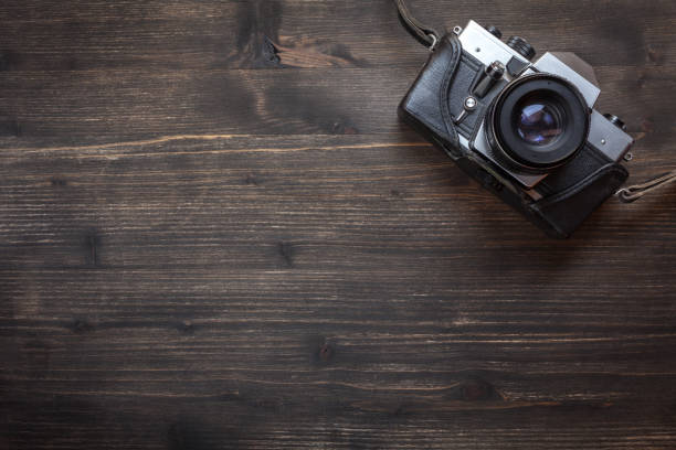 istock Old retro camera on wooden table background 941664712