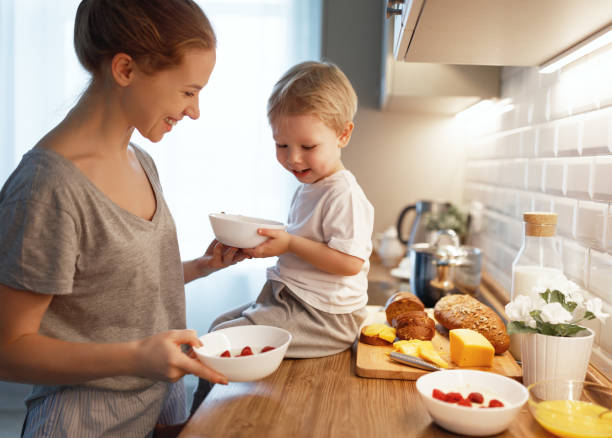 家族の朝食の準備。母親�し、息子料理をお粥を朝の赤ちゃん - mother son family cooking ストックフォトと画像