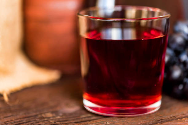 istock Red grape juice in glass and grapes close 941664774