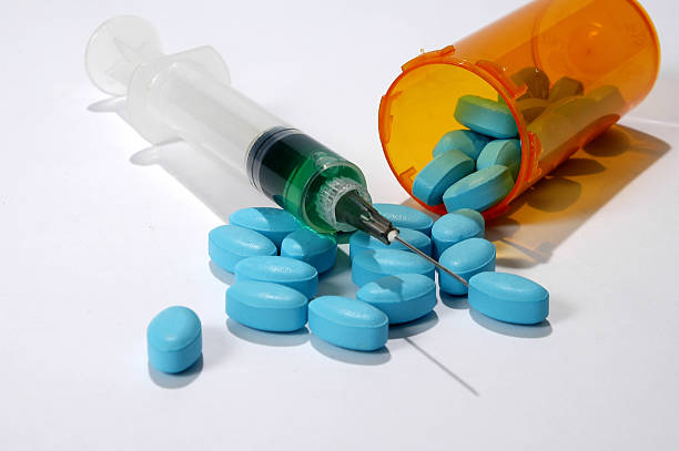 istock Blue medical pills and syringe on white background 94166513