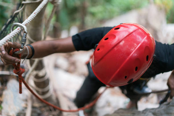 Above view of a man with sports helmet on zip lining in nature.