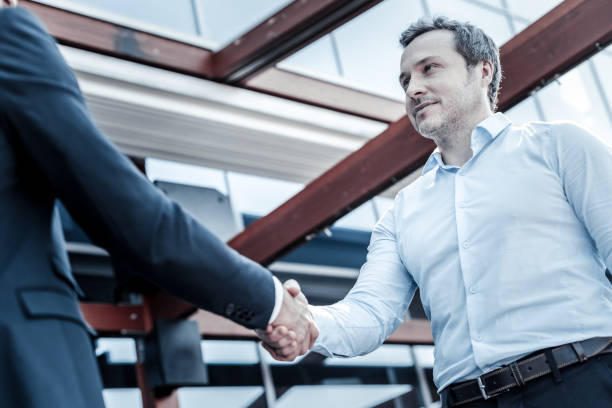 istock Positive nice man shaking hands with his business partner 941673384