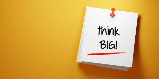istock White Sticky Note With Think Big Message And Red Push Pin On Yellow Background 941677132