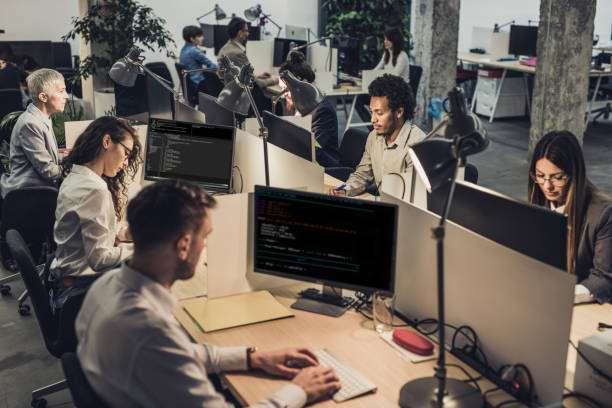 istock Large group of engineers working on computers at corporate office. 941677500