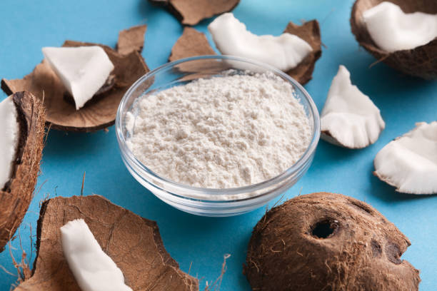 istock Plate with coconut flour and nuts on blue background 941677538
