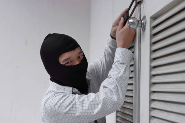 istock Thief in black balaclava trying to break into house 941678860