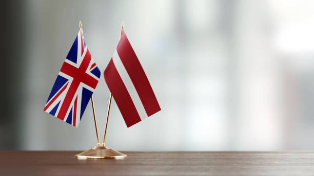istock British And Latvian Flag Pair On A Desk Over Defocused Background 941681628