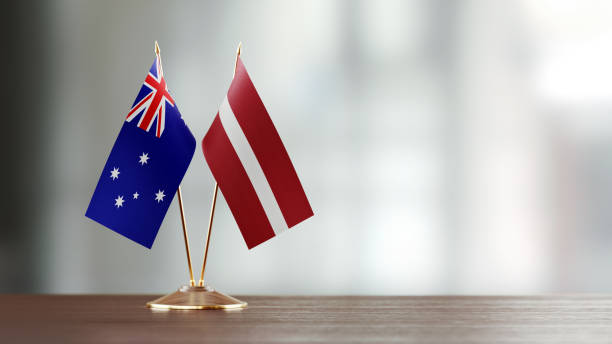 istock Australian And Latvian Flag Pair On A Desk Over Defocused Background 941681982