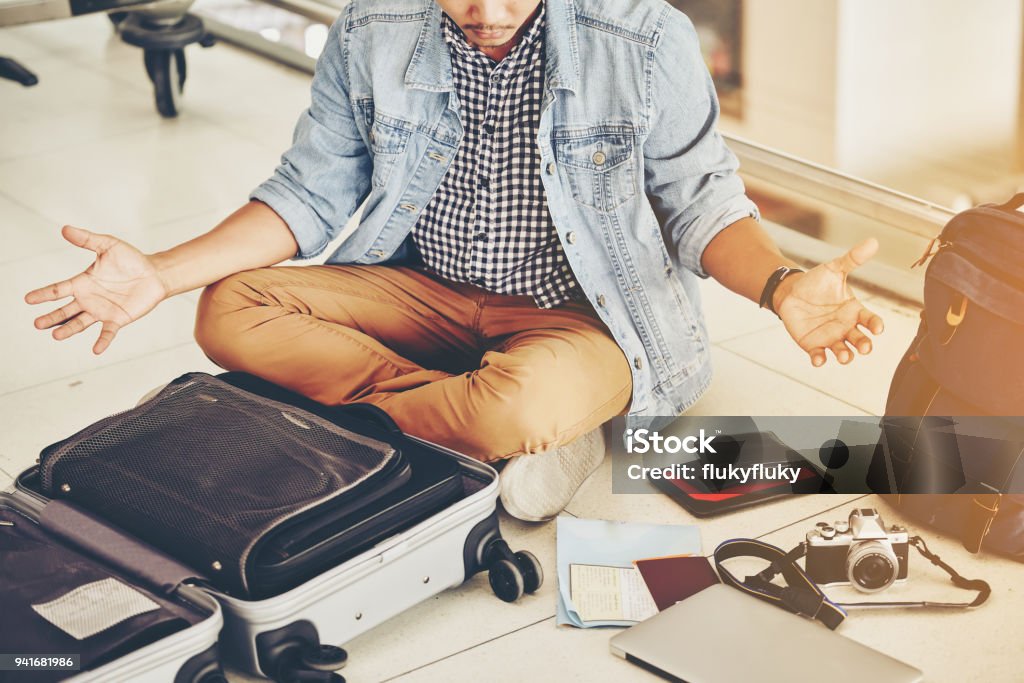 An Asian male traveler is experiencing the problem of need and lost value at the airport. Lost Stock Photo