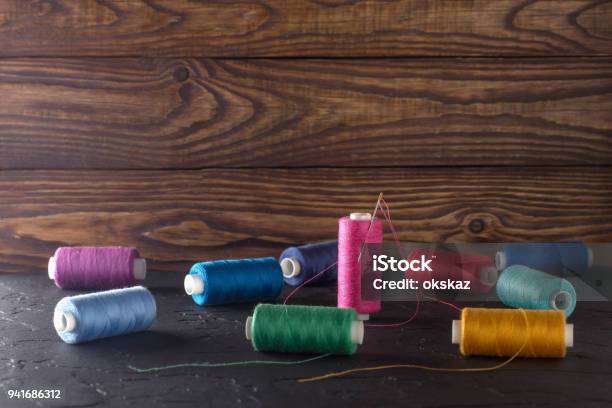 Sewing Thread On Coils Fabric Needles For Sewing On Wooden Background Set For Tailoring Products Knitting Hobbies And Handmade Dressmaker Sewing Accessories Stock Photo - Download Image Now