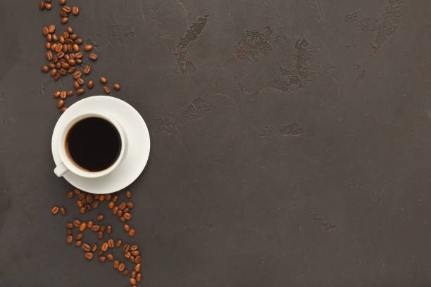 istock Cup of black coffee and scattered beans on gray background 941687350