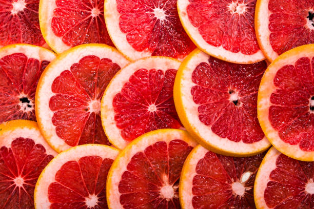 istock Sliced grapefruits, background, natural texture of citrus, top view, close-up 941689746