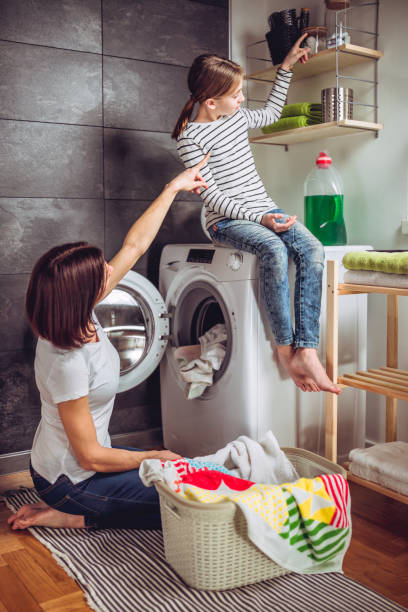 istock Daughter helping mother washing clothes 941690164