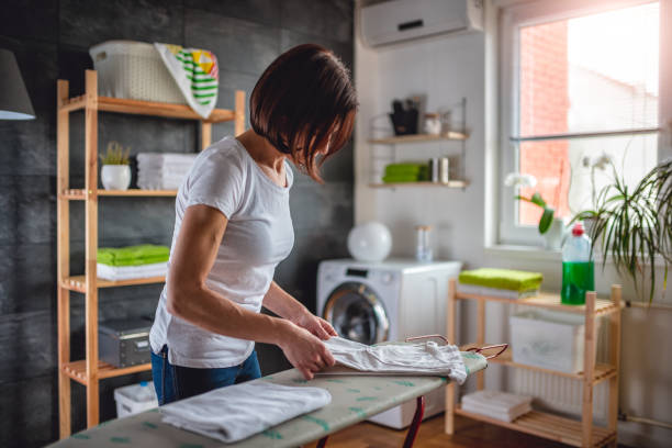 istock Women folding clothes on ironing board 941690856