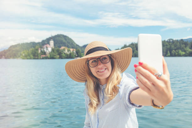 istock Cute girl using cellphone near the lake. 941694742