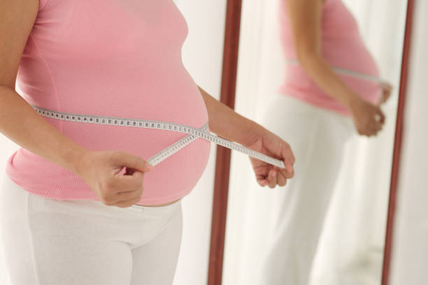 istock Pregnant Woman Measuring Belly 941694824