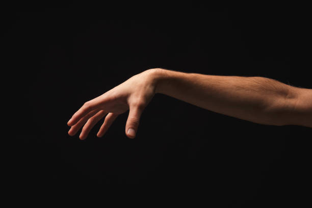 istock Male hand picking up something, cutout on black 941695582