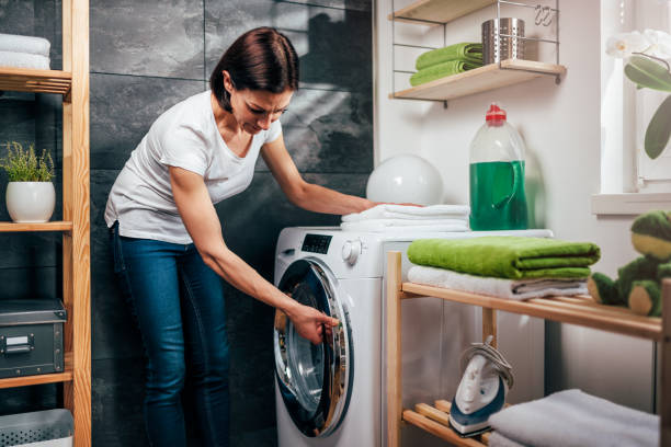 istock Woman closing washing machine door 941699352