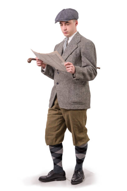 istock a young man in vintage clothes with hat, reading a newspaper, 1940 style 941701916
