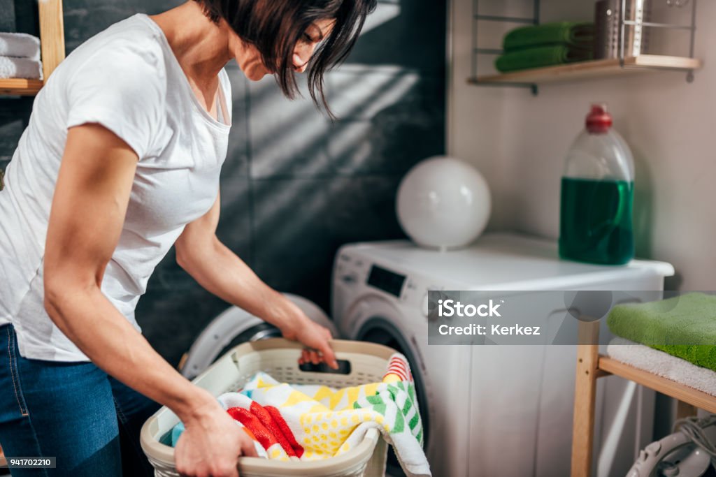 Woman carrying basket of laundry Woman wearing white shirt carrying basket of laundry Adult Stock Photo