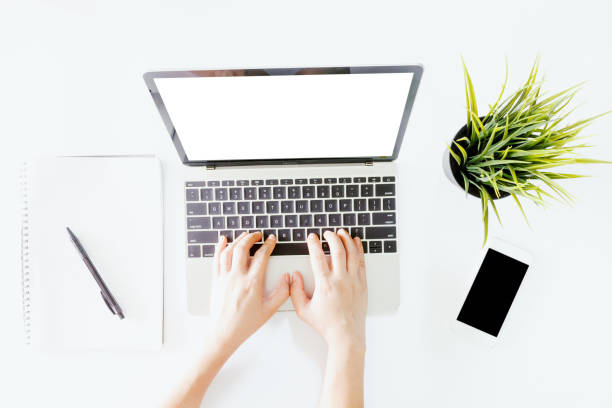 istock Top view of hand use laptop computer with blank screens on white office desk table.Flat lay 941702570