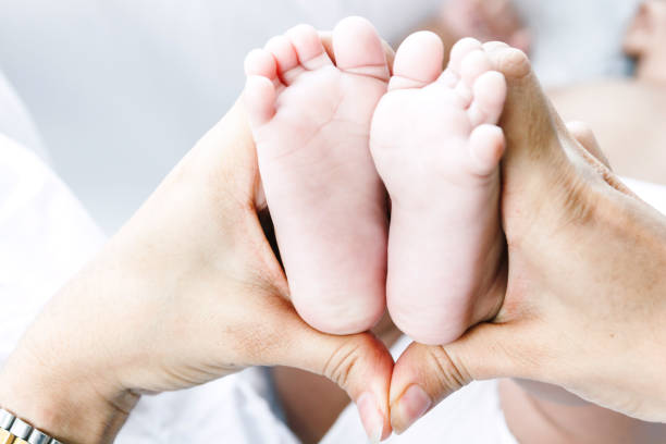 istock Newborn baby feet on mother hands 941702610