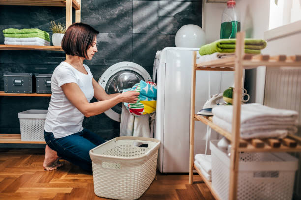 istock Woman taking clothes out washing machine 941705266