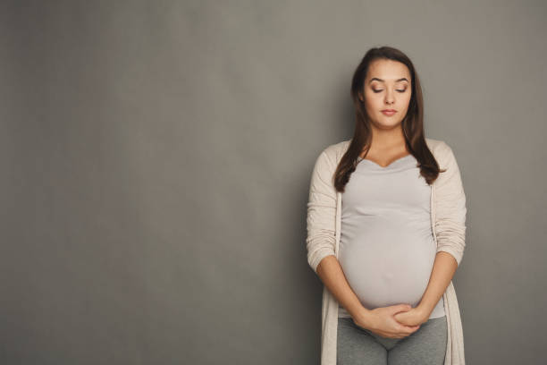 istock Pregnant woman with closed eyes at studio 941705352