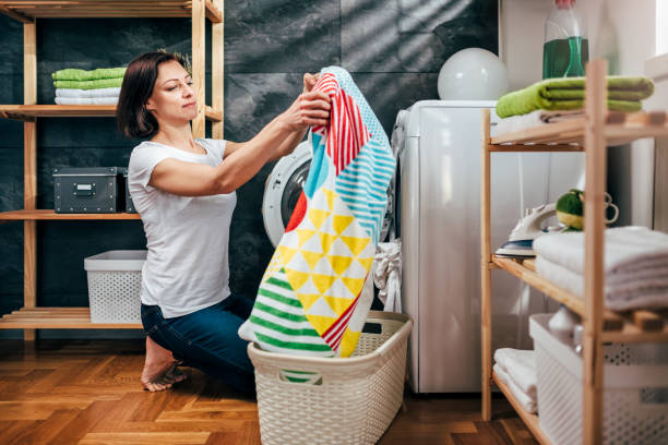 istock Woman taking clothes out washing machine 941705446