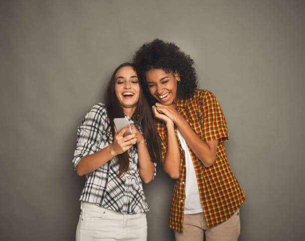 istock Two happy female friends using smartphone 941705914