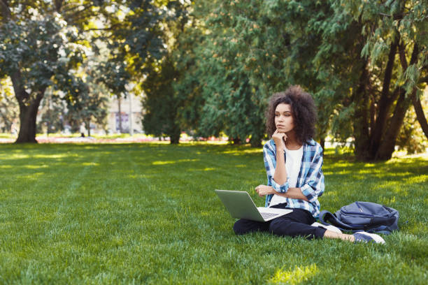 istock Serious young black woman using laptop in park 941711618
