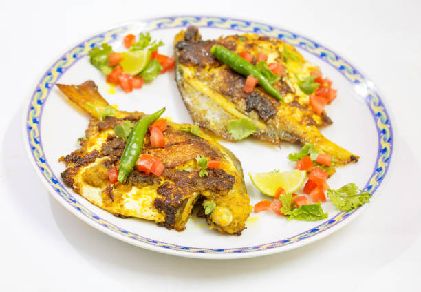 istock Crispy spicy fried Pomfret fish garnished with vegetables. 941712130