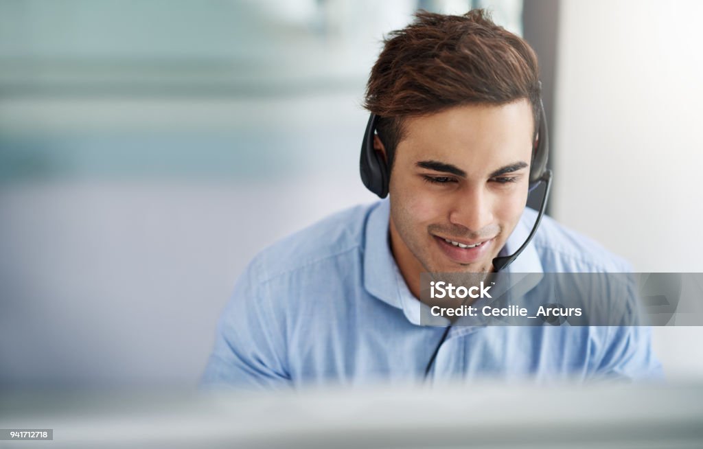 With him expect customer service at five star level Shot of a handsome young man working in a call center Call Center Stock Photo