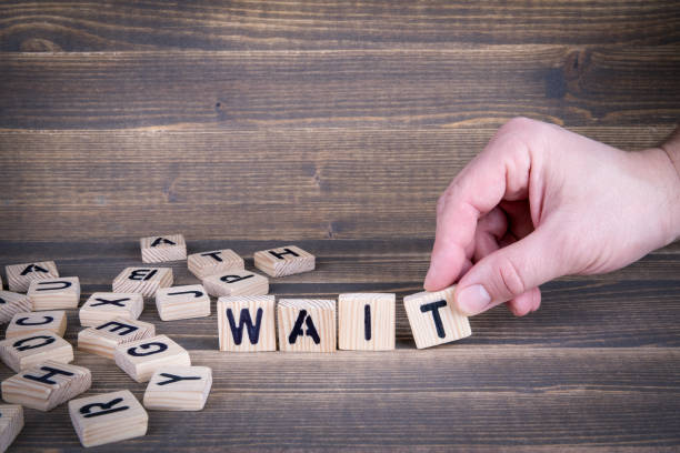 istock Wait. Wooden letters on the office desk, informative and communication background 941713066