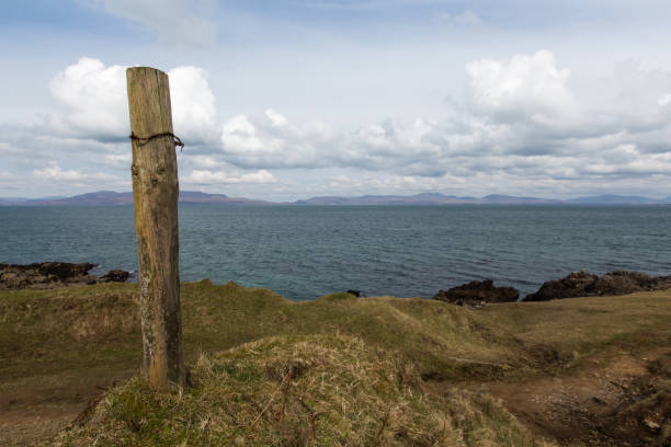 istock Wooden fence post and barbed wire on cliff edge 941715676