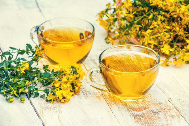 istock Two cups of Hypericum herbal (Tutsan) tea on wooden grunge table 941723292