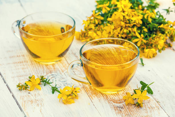 istock Two cups of Hypericum herbal (Tutsan) tea on wooden grunge table 941723482